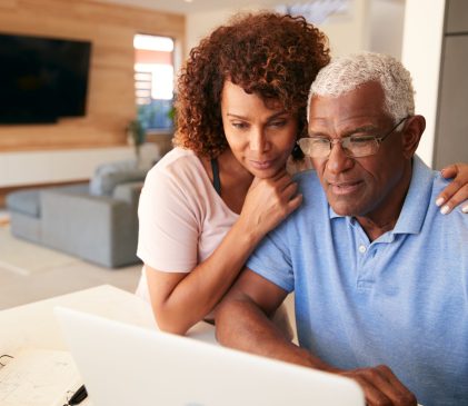Senior,African,American,Couple,Using,Laptop,To,Check,Finances,At